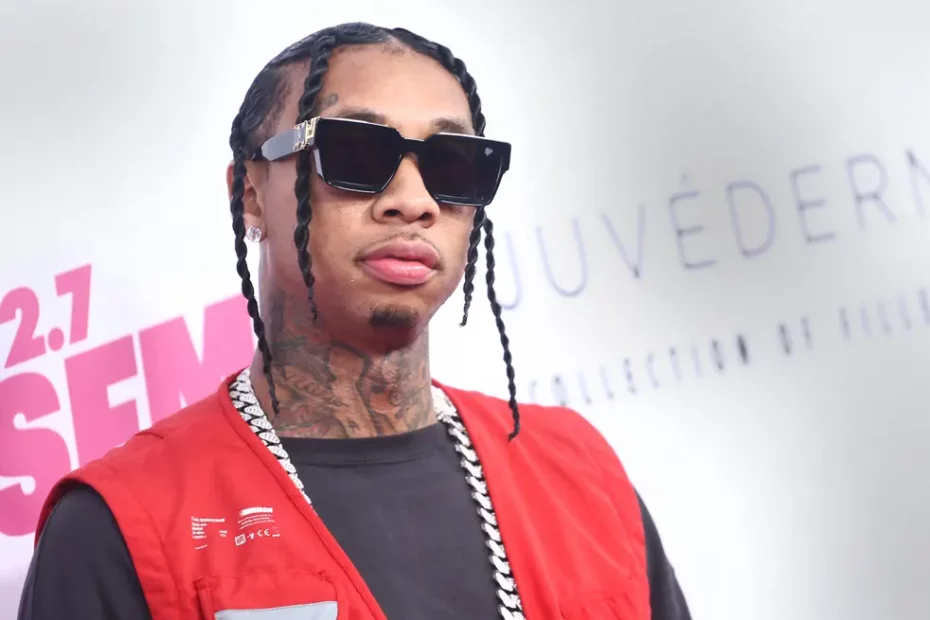 Image of tyga wearing red vest and black shirt